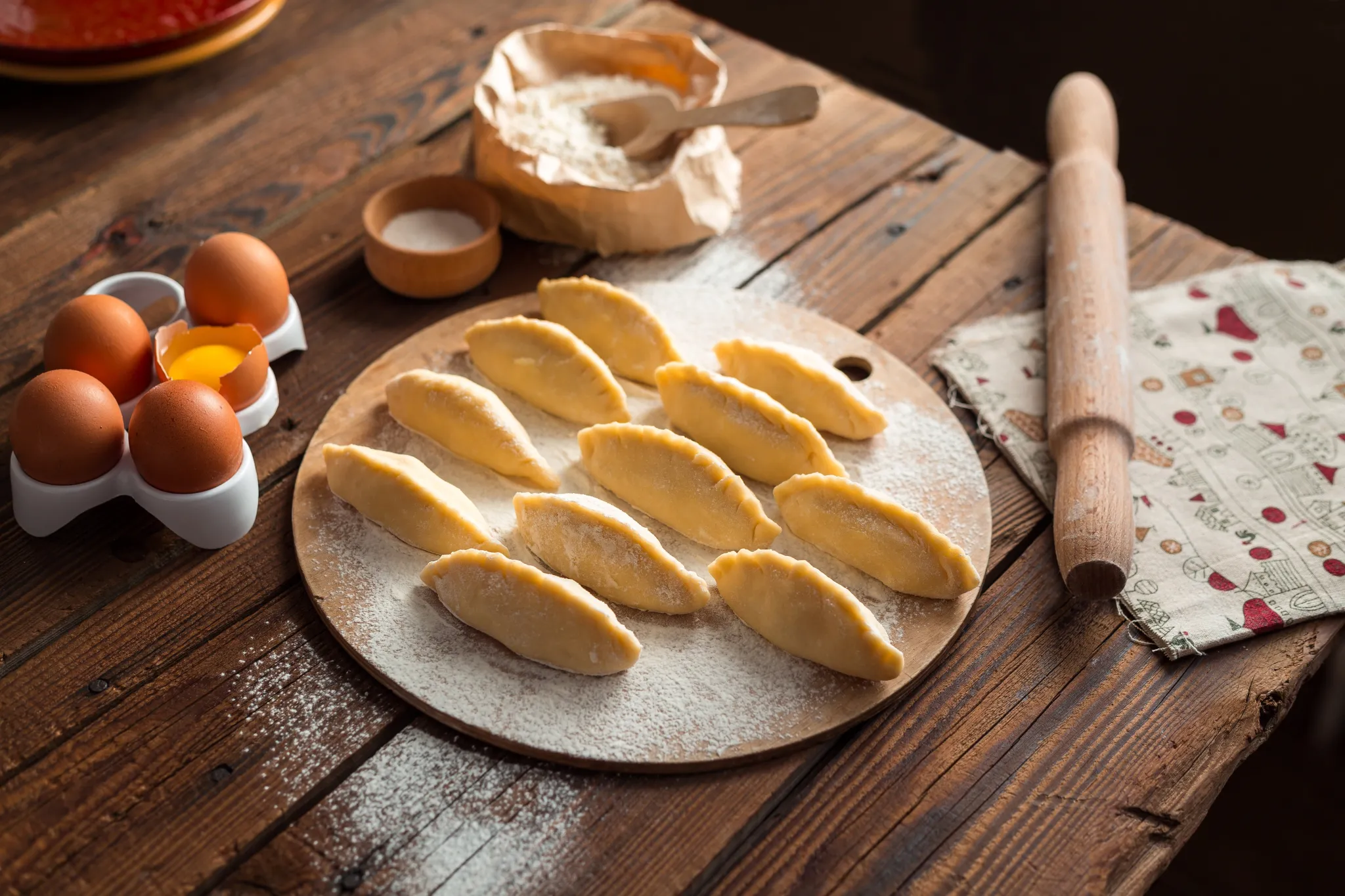 Empanadas armadas sobre tabla enharinada con huevos y palote